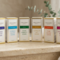 All six Shigeru Skin Elixir boxes lined up on a travertine spa ledge